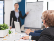 Na zdjęciu dwie kobiety, jedna prowadzi szkolenie, druga siedzi przy stole