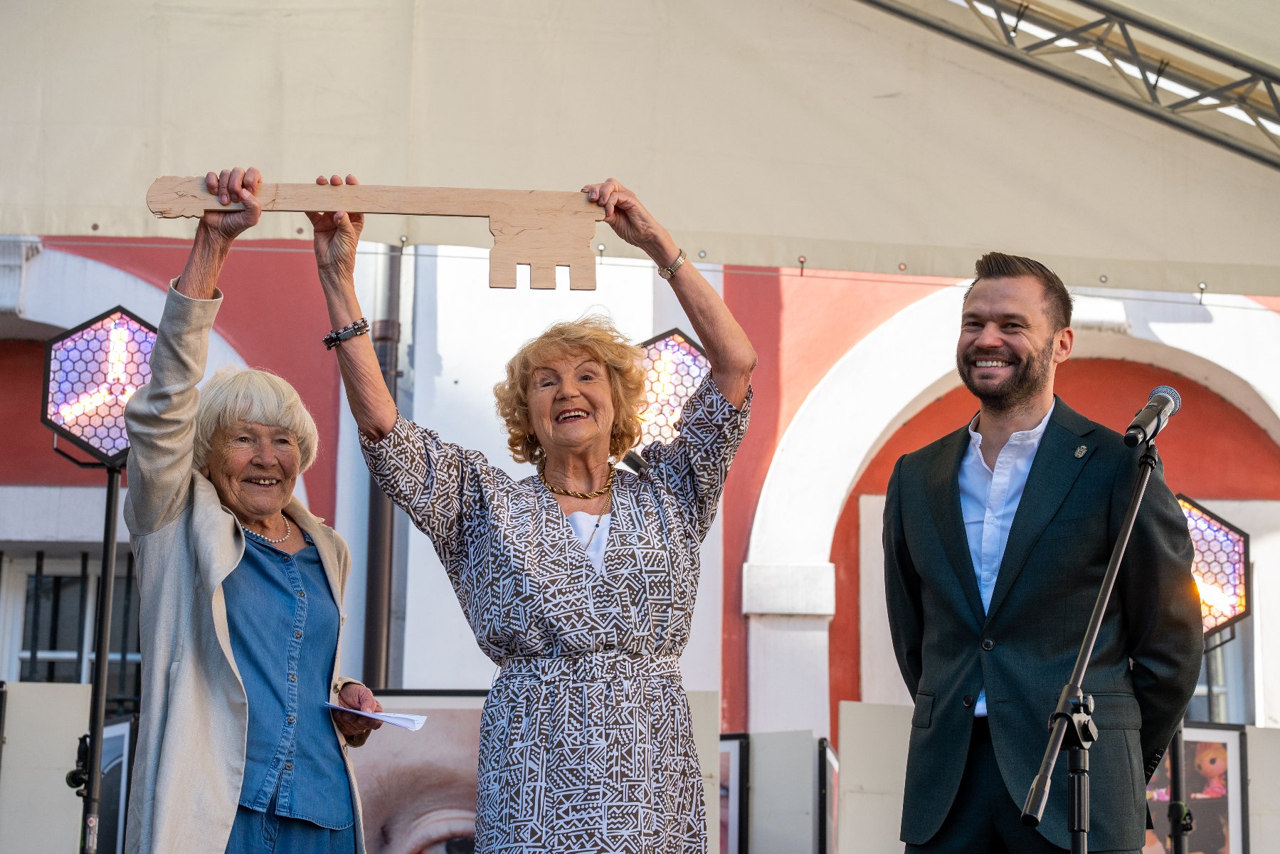 Na zdjęciu dwie seniorki trzymające duże klucze, obok nich uśmiechnięty zastępca prezydenta Poznania