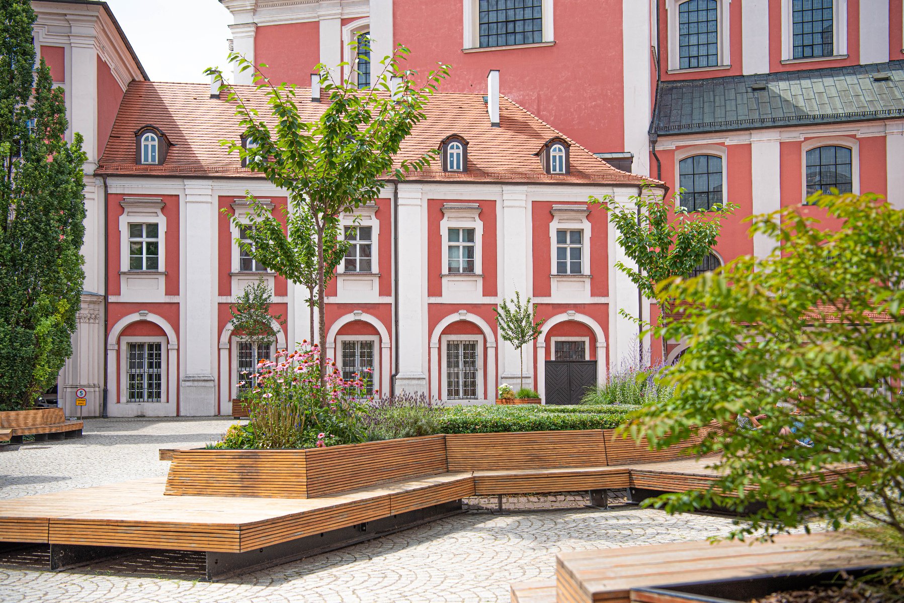 Na zdjęciu dziedziniec urzędu, widać ławki, na pierwszym planie rośliny