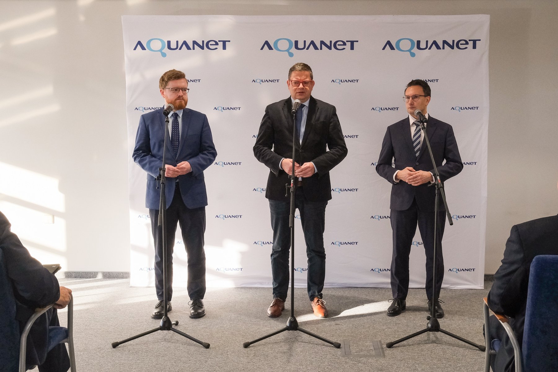 Na zdjęciu grupa ludzi przy stołach podpisujących dokumenty