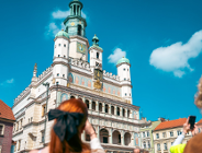 Na zdjęciu ludzie robiący zdjęcia poznańskiemu Ratuszowi