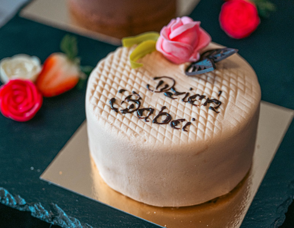 Na zdjęciu niewielki tort ozdobiony różą i napisem: Dzień Babci