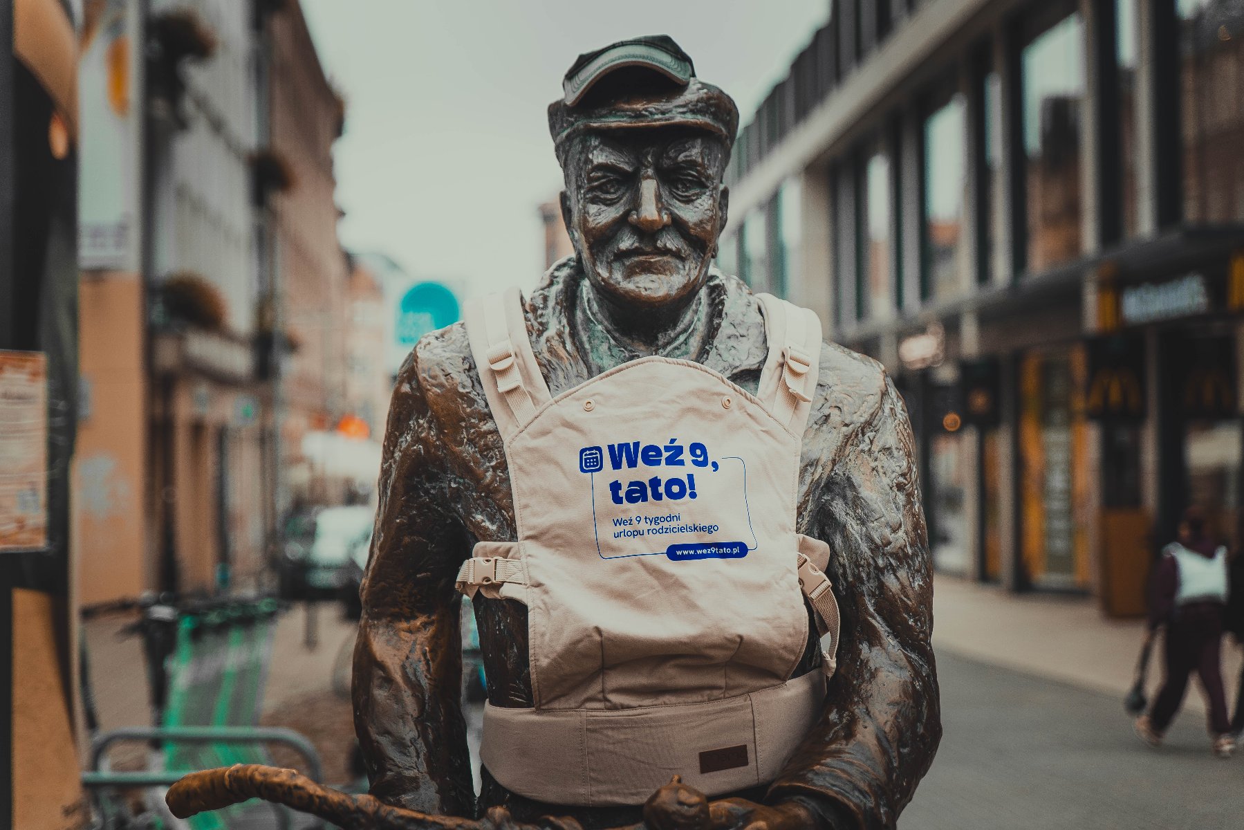 Na zdjęciu pomnik Starego Marycha z nosidełkiem, na nim napis "Weź 9, Tato"