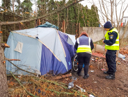 Na zdjęciu pracownica MOPR i strażnik miejski stoją u wejścia do namiotu osoby w kryzysie bezdomności