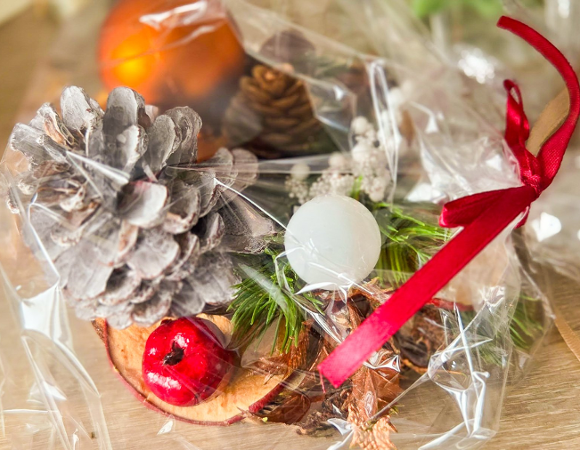 Na zdjęciu stroik świąteczny owinięty w folię, z kokardą