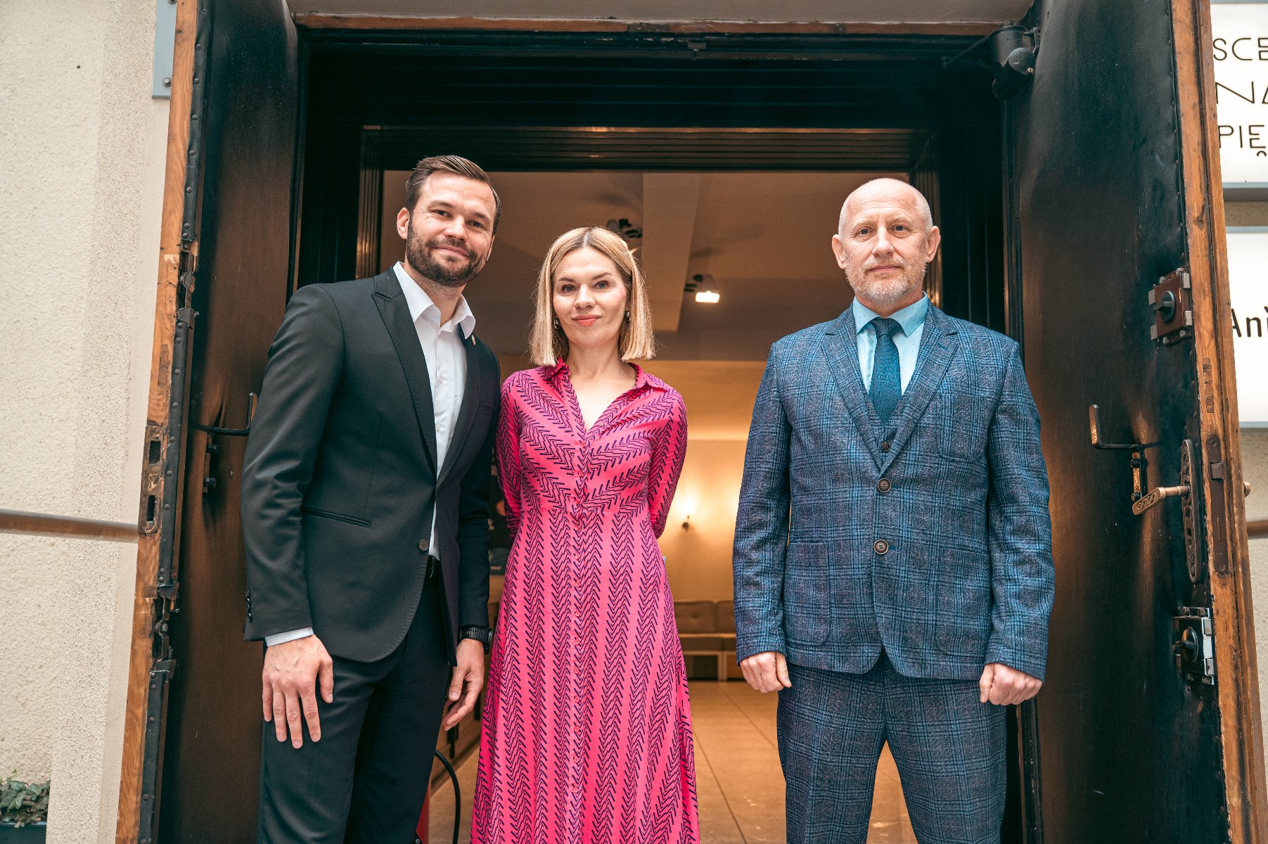 Na zdjęciu wejście do sceny na piętrze, na pierwszym planie ludzie z parasolami