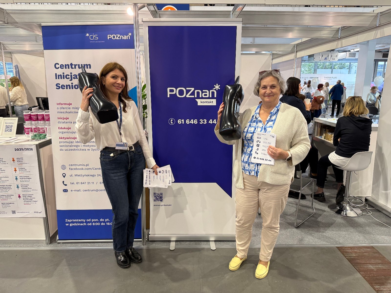 Na zdjęciu widać pracowników Biura Poznań Kontakt pozujących na tle niebieskiego rollupu z logiem biura