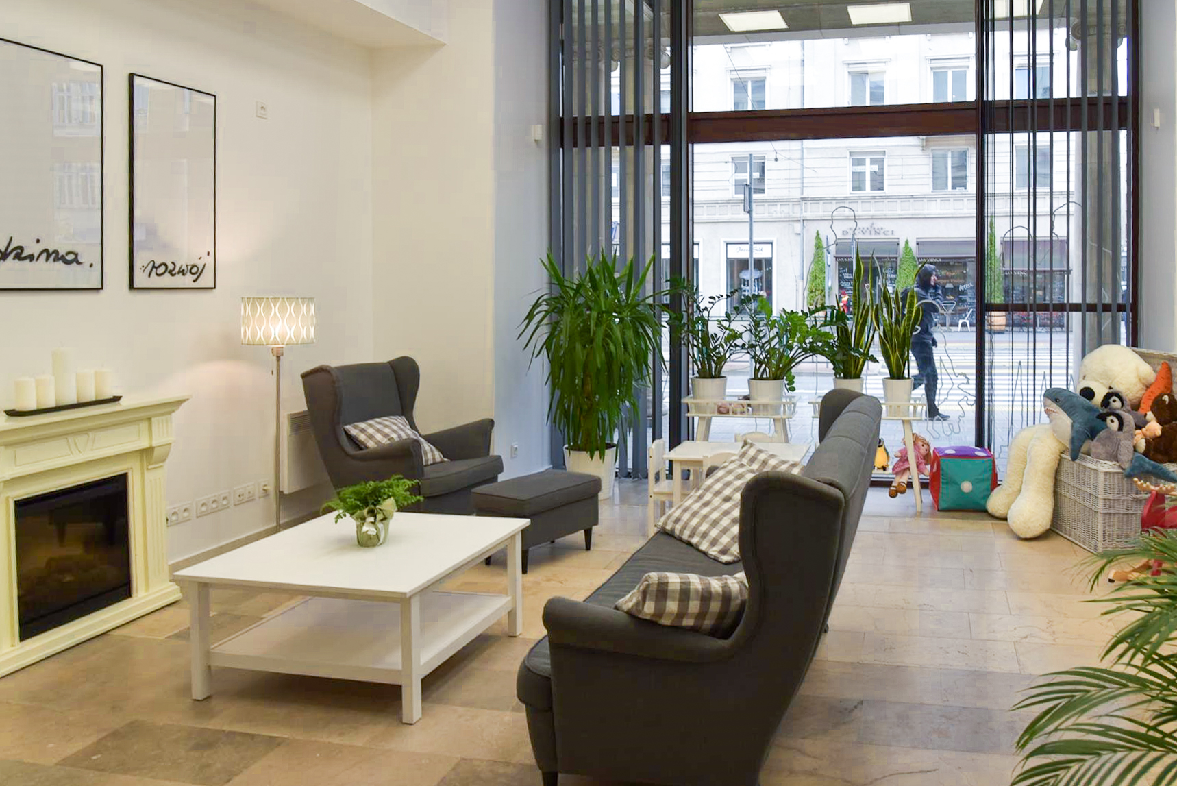 Na zdjeciu wnętrze CIR, widać kanapę, fotel, stolik, obok leżą zabawki, w tle duże okno