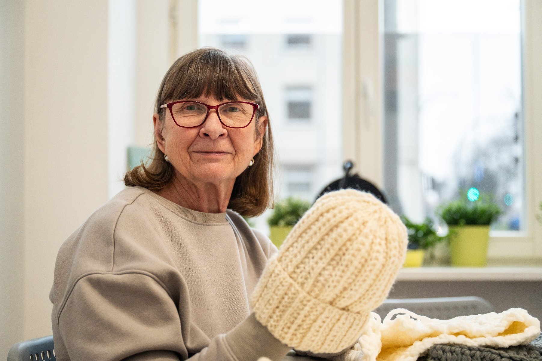 Na zdjęciu wydziergana czapka, w tle kobiety