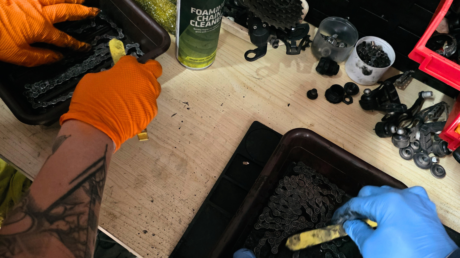 Na zdjęciu znajdują się łańcuchy rowerowe który czyszczone są szczotkami.