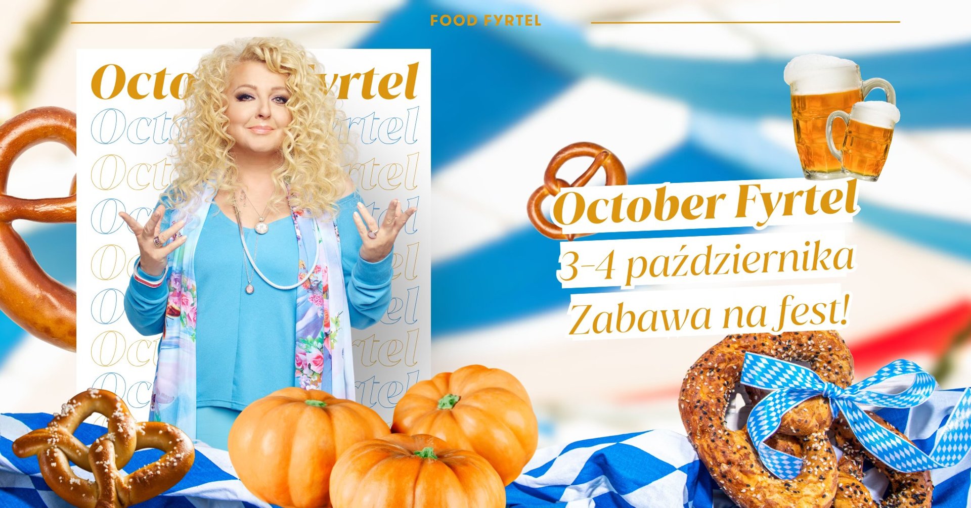 Na stole z biało-niebieskim obrusem w krate leżą przysmaki jak dynia, precle i piwo. W tle zdjęcie Magdy Gessler.