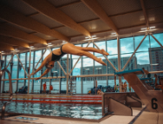 Osoba skacząca do basenu