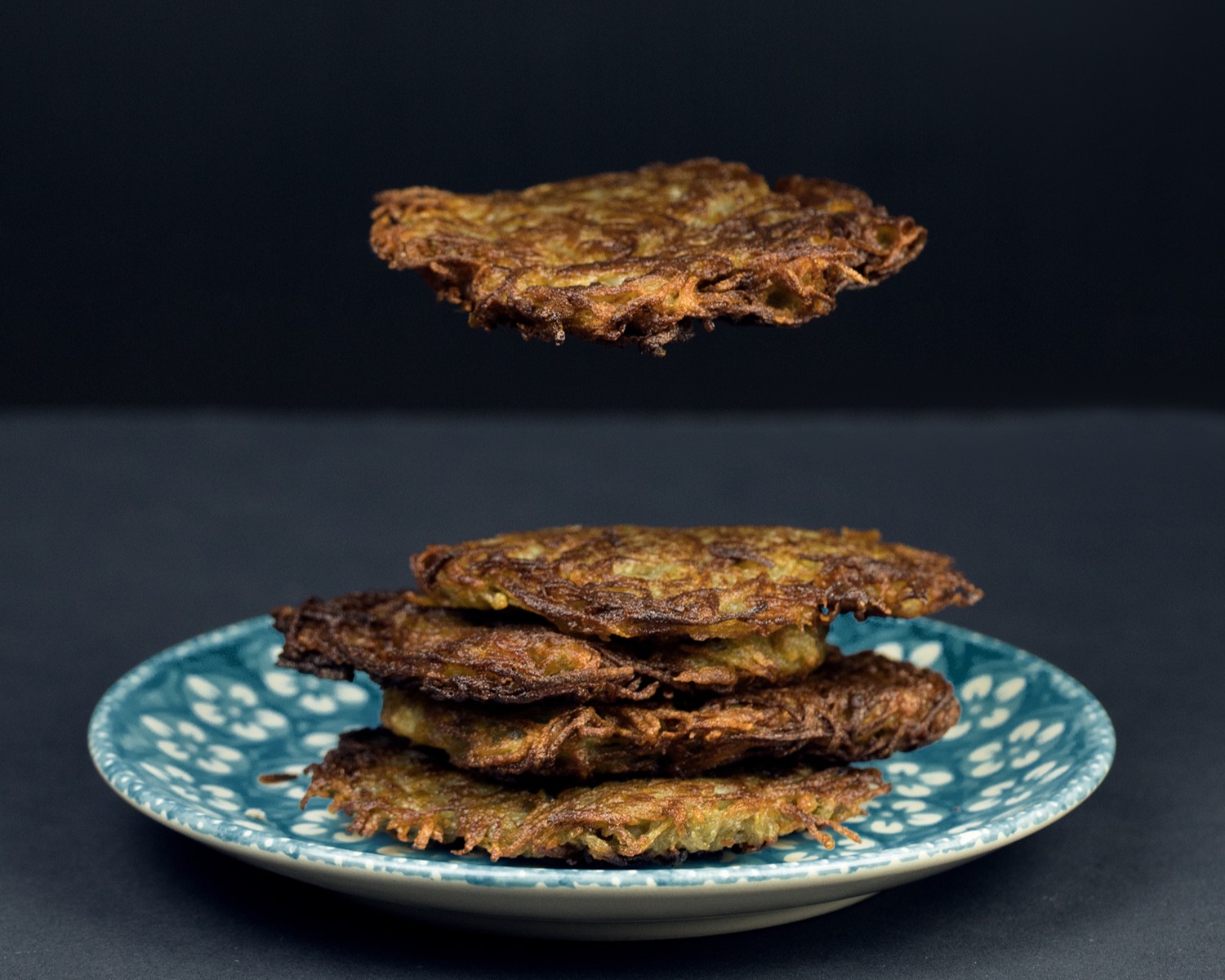 Placki ziemniaczane lewitujące nad talerzem.