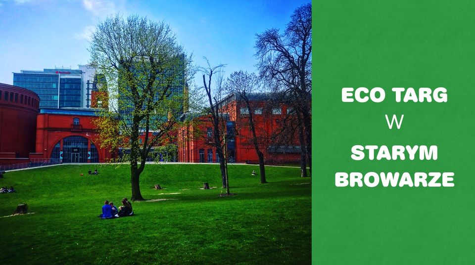 Po lewej zielony park przy Starym Browarze, a po prawej stronie baneru białe napisy na zielonym tle.