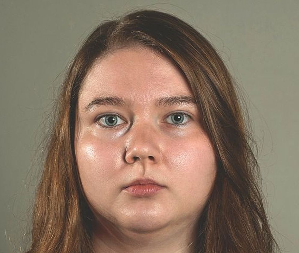 Poetka ma długie, rudawe włosy i okrągłą rozświetloną twarz.