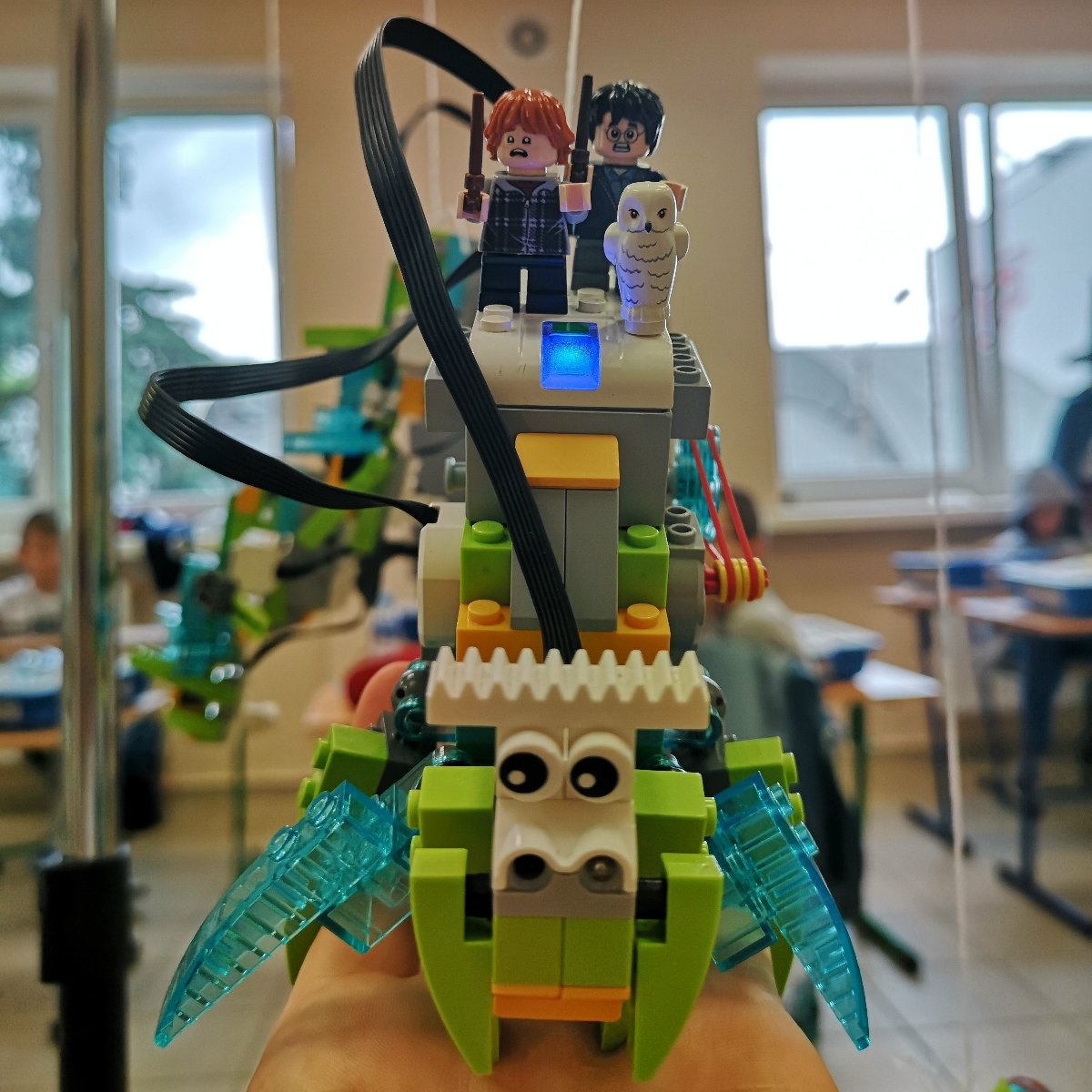 Robot z klocków Lego, przedstawiający bajkowe stworzenie na którym siedzą postaci znane z serii powieści Harry Potter.