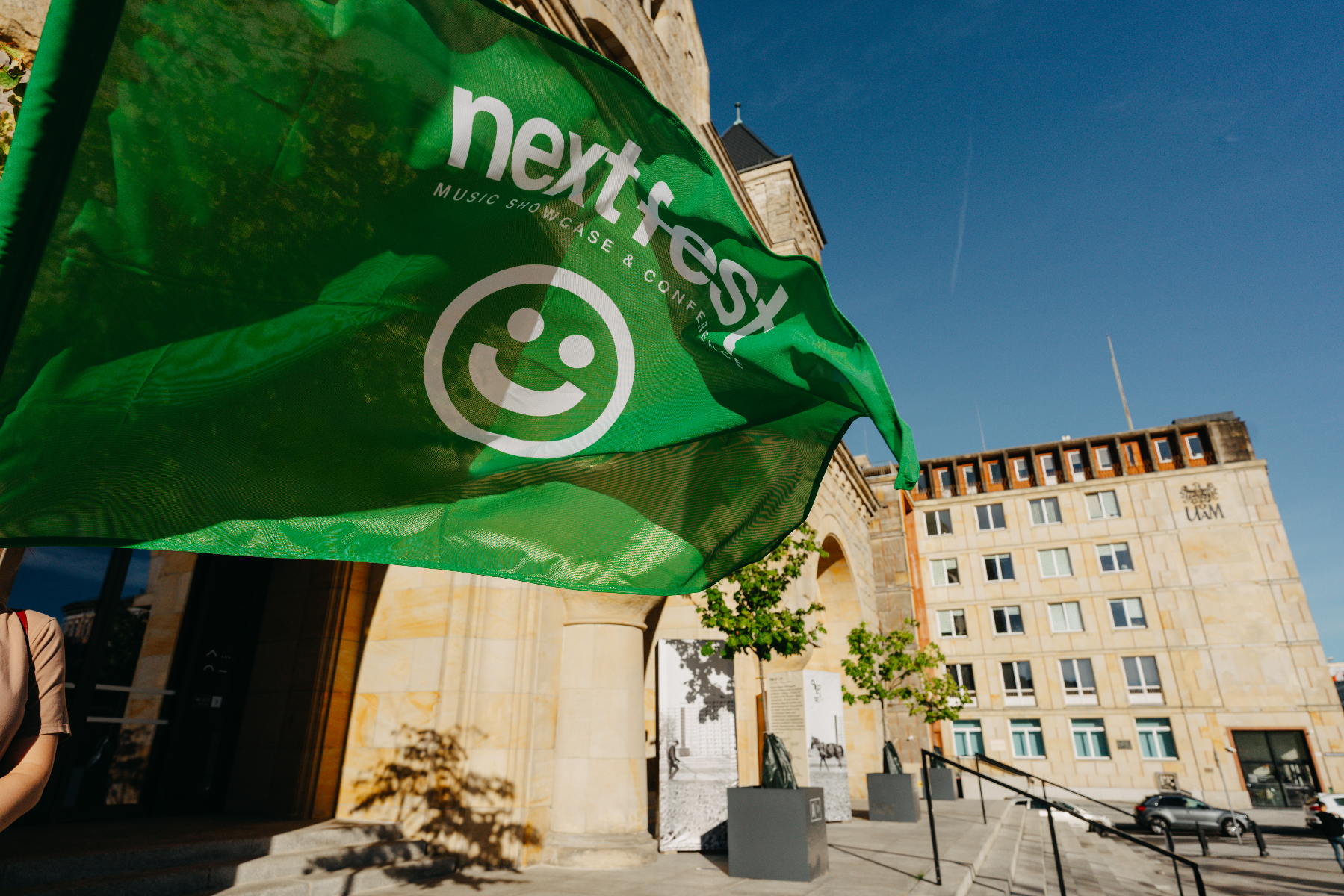 Powiewająca zielona flaga Next Fest przed CK Zamek