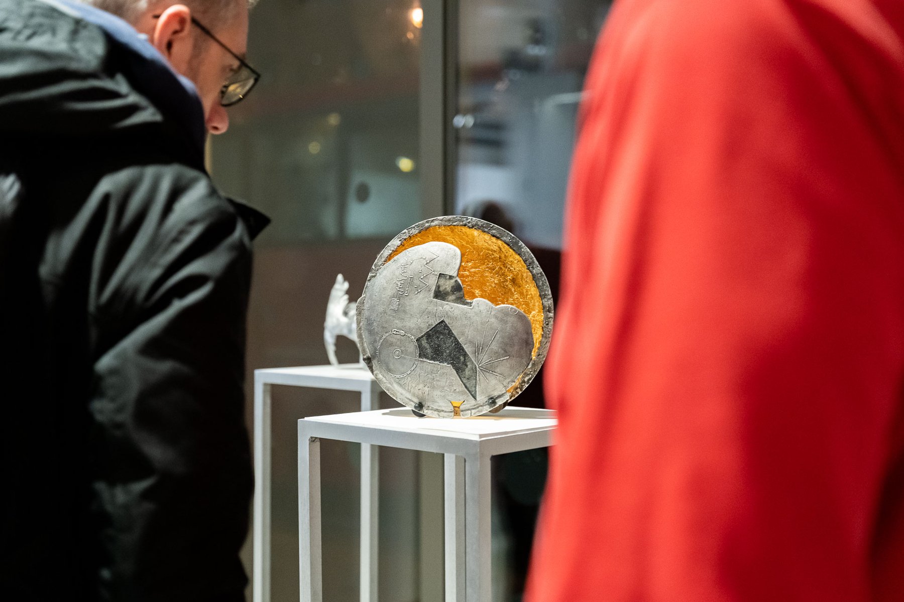 Rzeźba o kształcie okręgu, ze stali i złota, ze znakami symbolicznymi misji Voyager