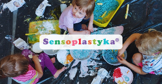 Dzieci siedzą na trawie