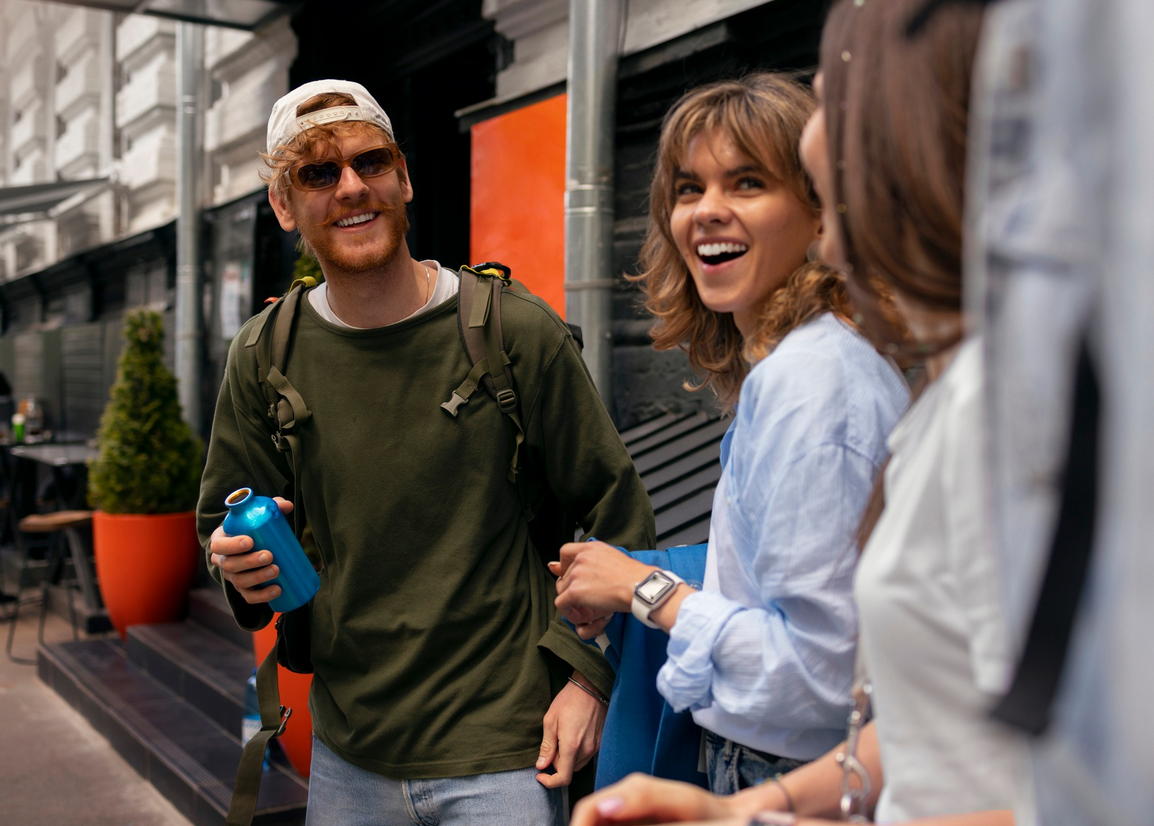 Roześmiana grupa osób na miejskiej ulicy.