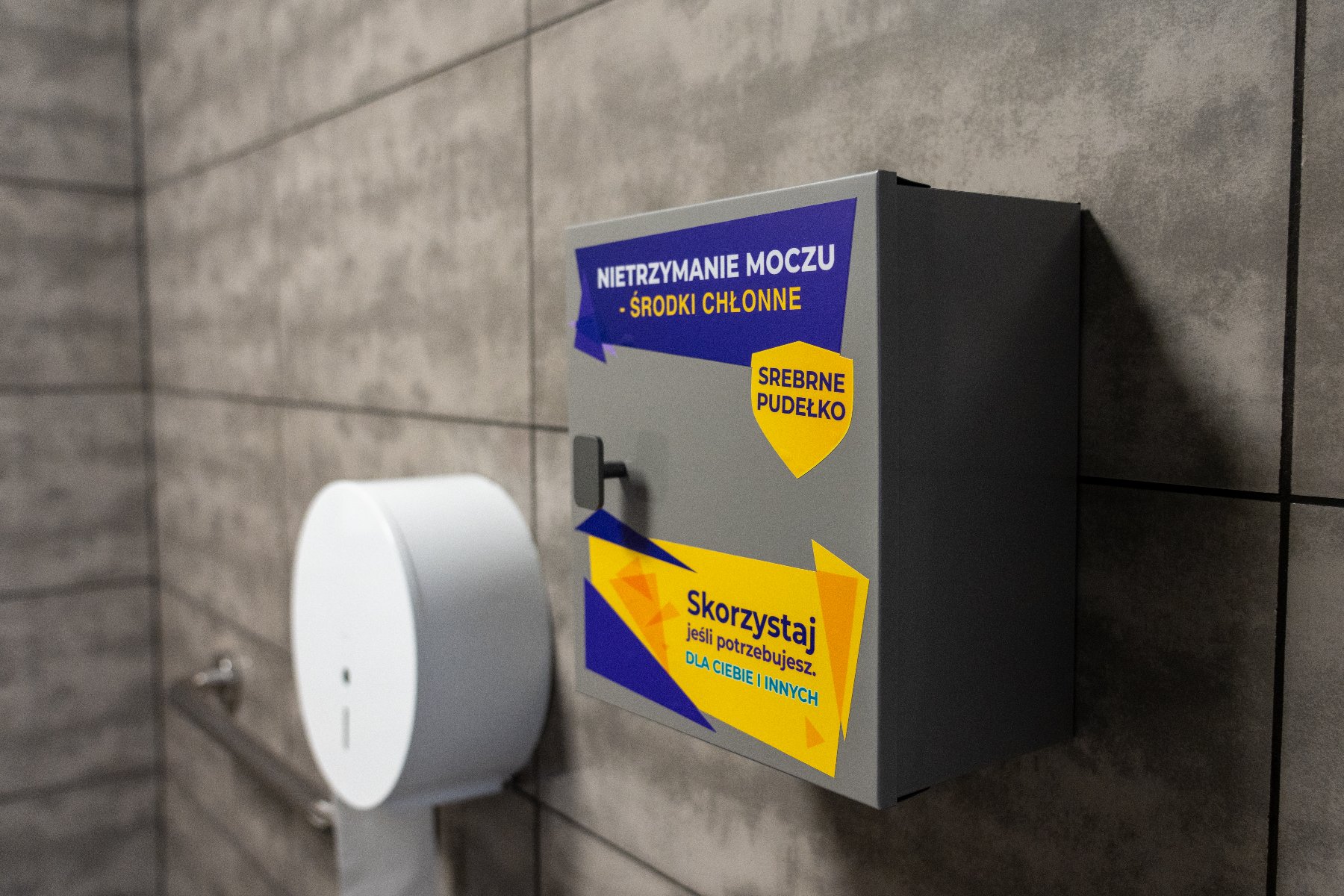 Srebrne pudełko zainstalowane w toalecie na ścianie
