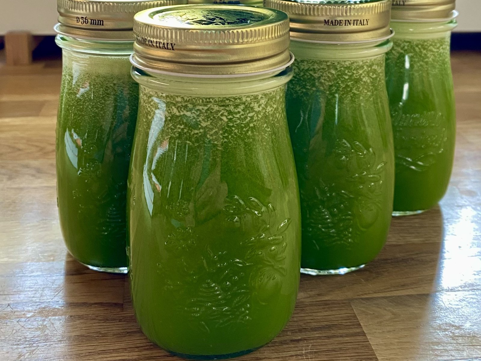 Szklane buteleczki, które są wypełnione zielonym płynem.