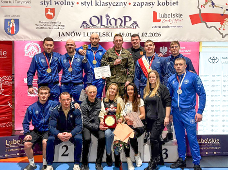 Tadeusz Michalik z medalem na MP seniorów na zakończenie sportowej kariery, fot. Maciej Kula - zawodnik stoi z medalem w wojskowym mundurze, obok niego inne osoby z klubowych, niebieskich dresach z medalami, a poniżej panie trzymające nagrody oraz starszy mężczyzna