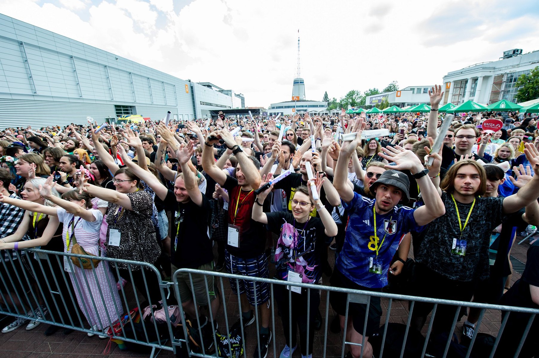 tłum ludzi za barierkami przed sceną koncertową
