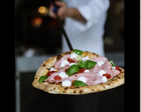 Pizza z suszonymi pomidorami i bazylią.