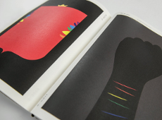 Wnętrze książki. Książka otworzona na stronach prezentujących plakaty z ręką i herbem.