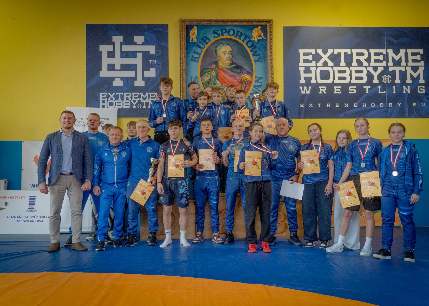 Zawodnicy Sobieskiego Poznań z medalami za Międzywojewódzkie Mistrzostwa Młodzików, fot. Maciej Kula - na sali klubowej Sobieski Poznań stoją zawodnicy w strojach klubowych z medalami i dyplomami oraz trenerami