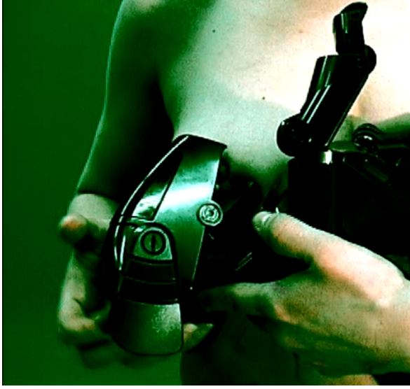 Fragment kobiety, która trzyma jakieś urządzenie zasłaniając sobie biust.