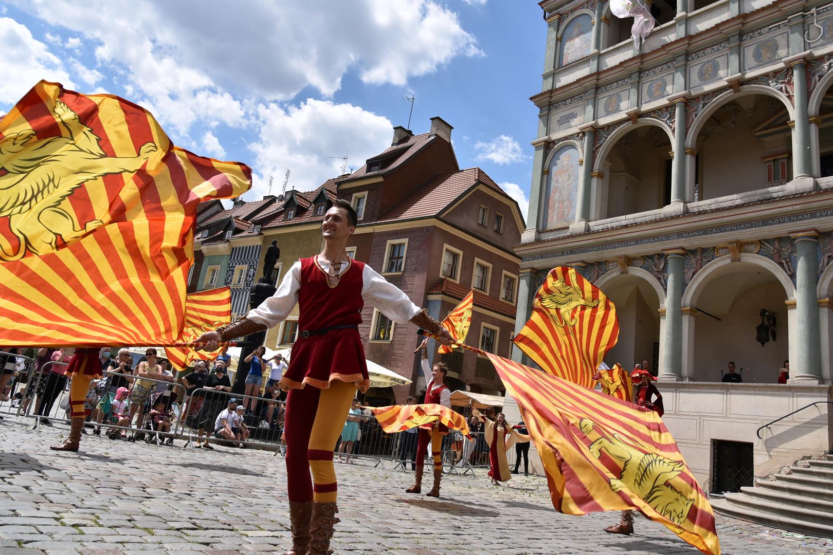 Na zdjęciu mężczyzna z flagami na płycie starego Rynku.