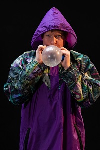 Photo of a man blowing a baloon.