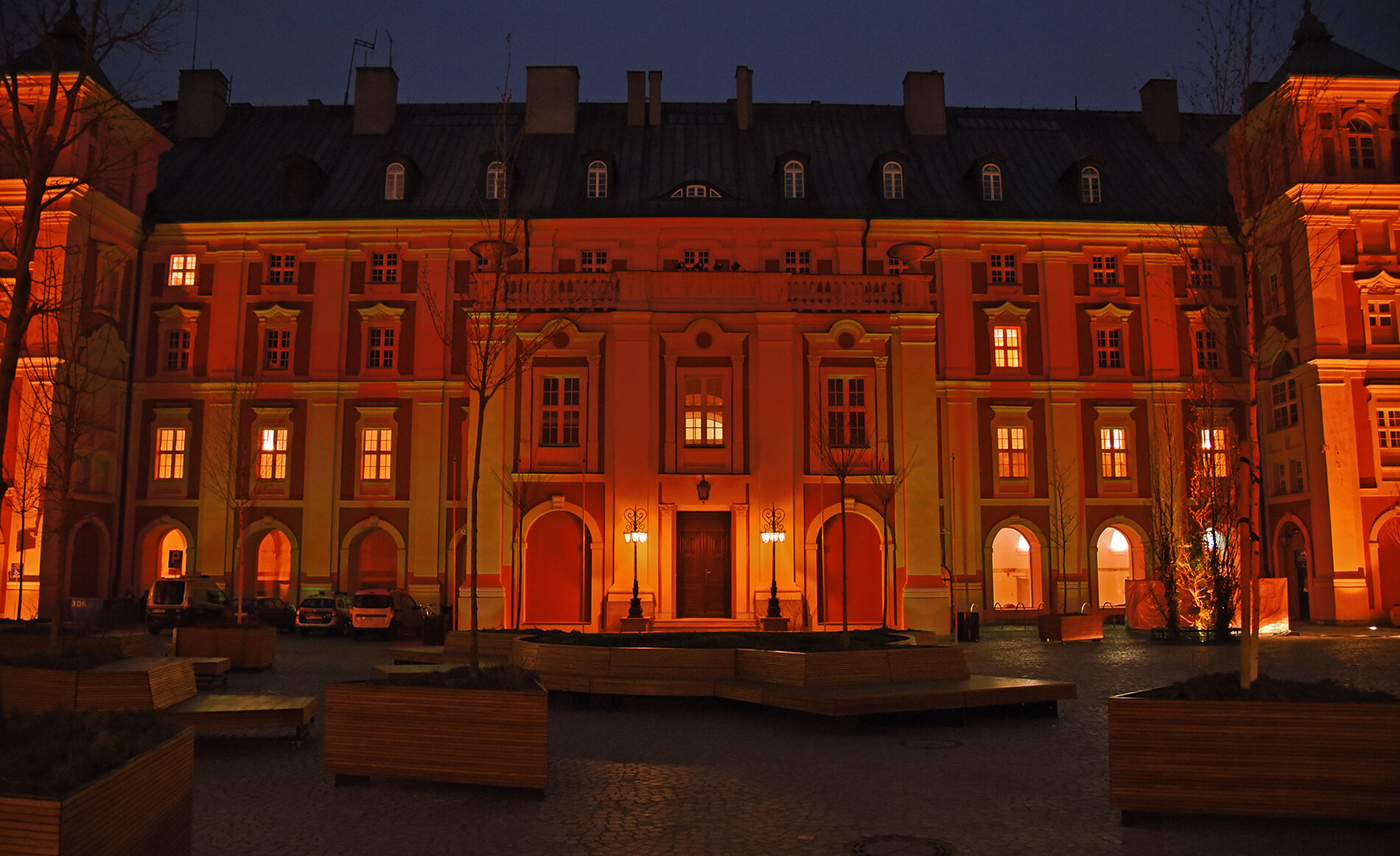 Zdjęcie przedstawia budynek urzędu rozświetlony na czerowno. Zdjęcie zrobiono o zmroku.