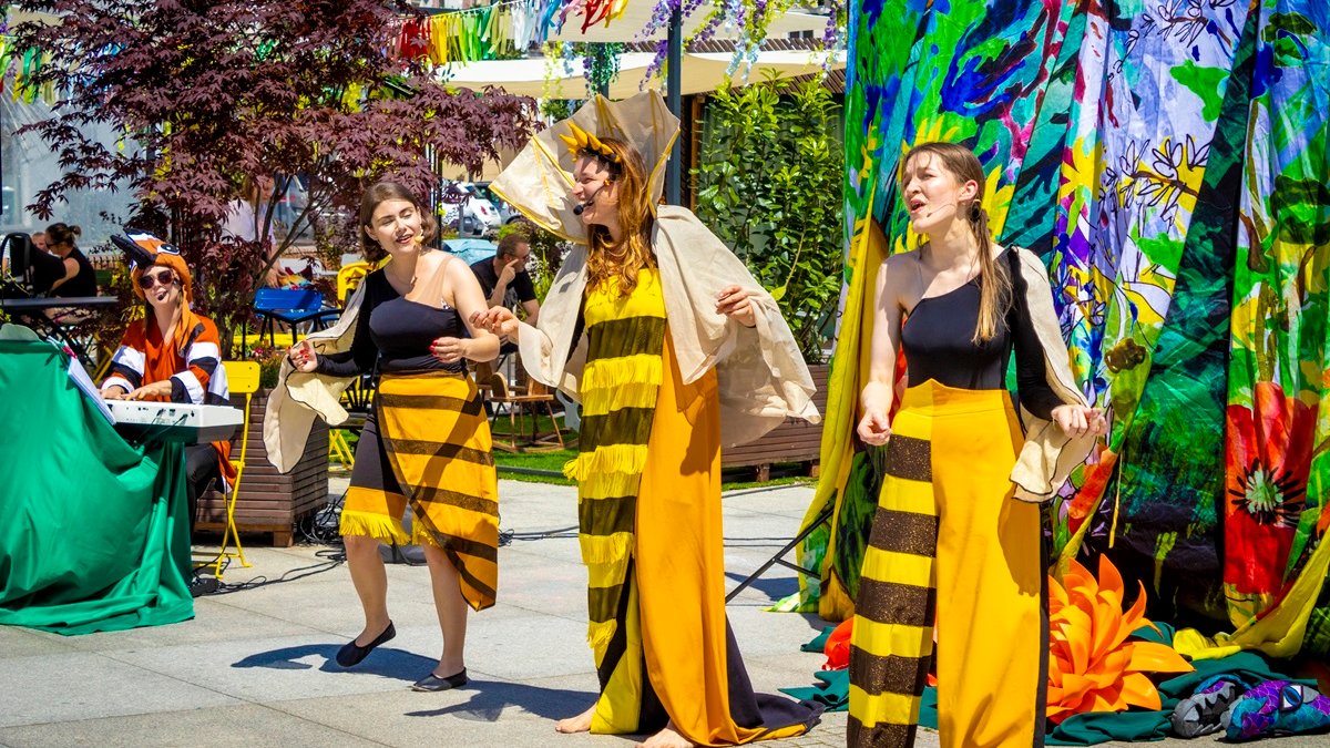 Zdjęcie przedstawia dwie tańczące kobiety przebrane za pszczoły.