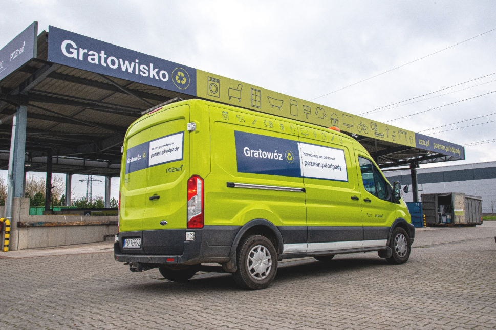 Zdjęcie przedstawia gratowóz w kolorze jasnej zieleni na tle gratowiska