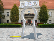 Zdjęcie przedstawia instalację w kształcie dużej dziurki od klucza, stojącej na placu. Na górze tej instalacji znajduje się napis PBO.