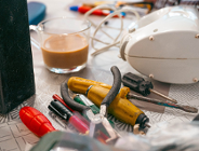 Zdjęcie przedstawia leżące na stole narzędzia i mikser oraz szklankę z kawą.