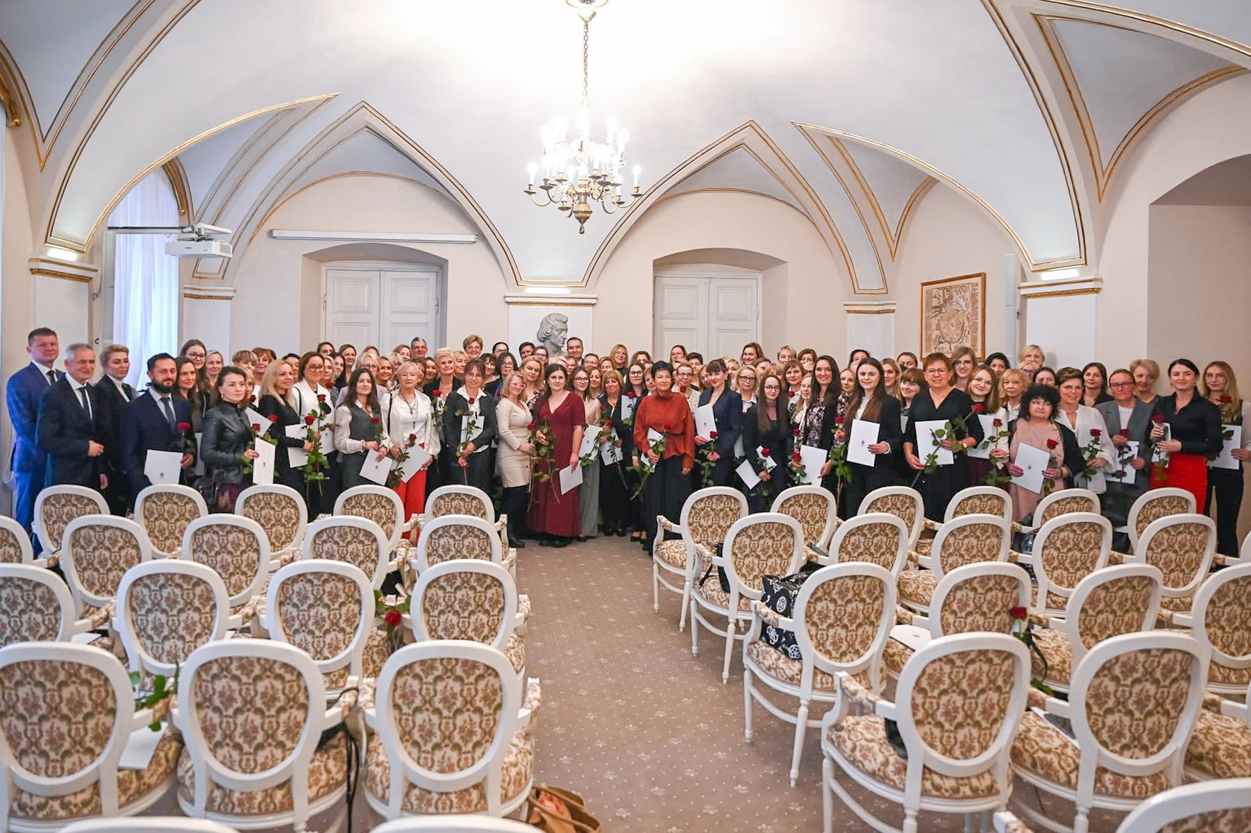 Zdjęcie przedstawia mężcyznę wręczającego kwiaty kobiecie.