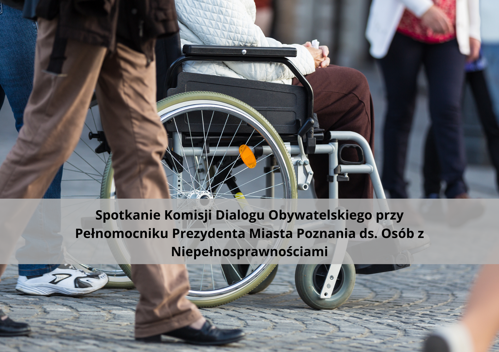 Zdjęcie przedstawia nogi jednej osoby oraz osobę siedzącą na wózku inwalidzkim od piersi w dół. Podpis pod zdjęciem: "Spotkanie Komisji Dialogu Obywatelskiego przy Pełnomocniku Prezydenta Miasta Poznania ds. Osób z Niepełnosprawnościami".