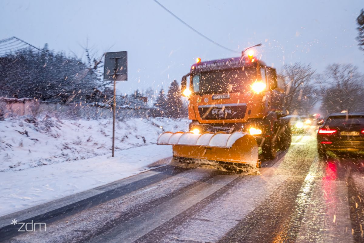 Zdjęcie przedstawia pług odśnieżający drogę miejską