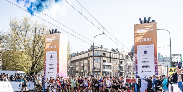 Zdjęcie przedstawia tłum biegaczy na starcie.