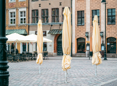 Zdjęcie przedstawia złożone parasole na płycie starego rynku