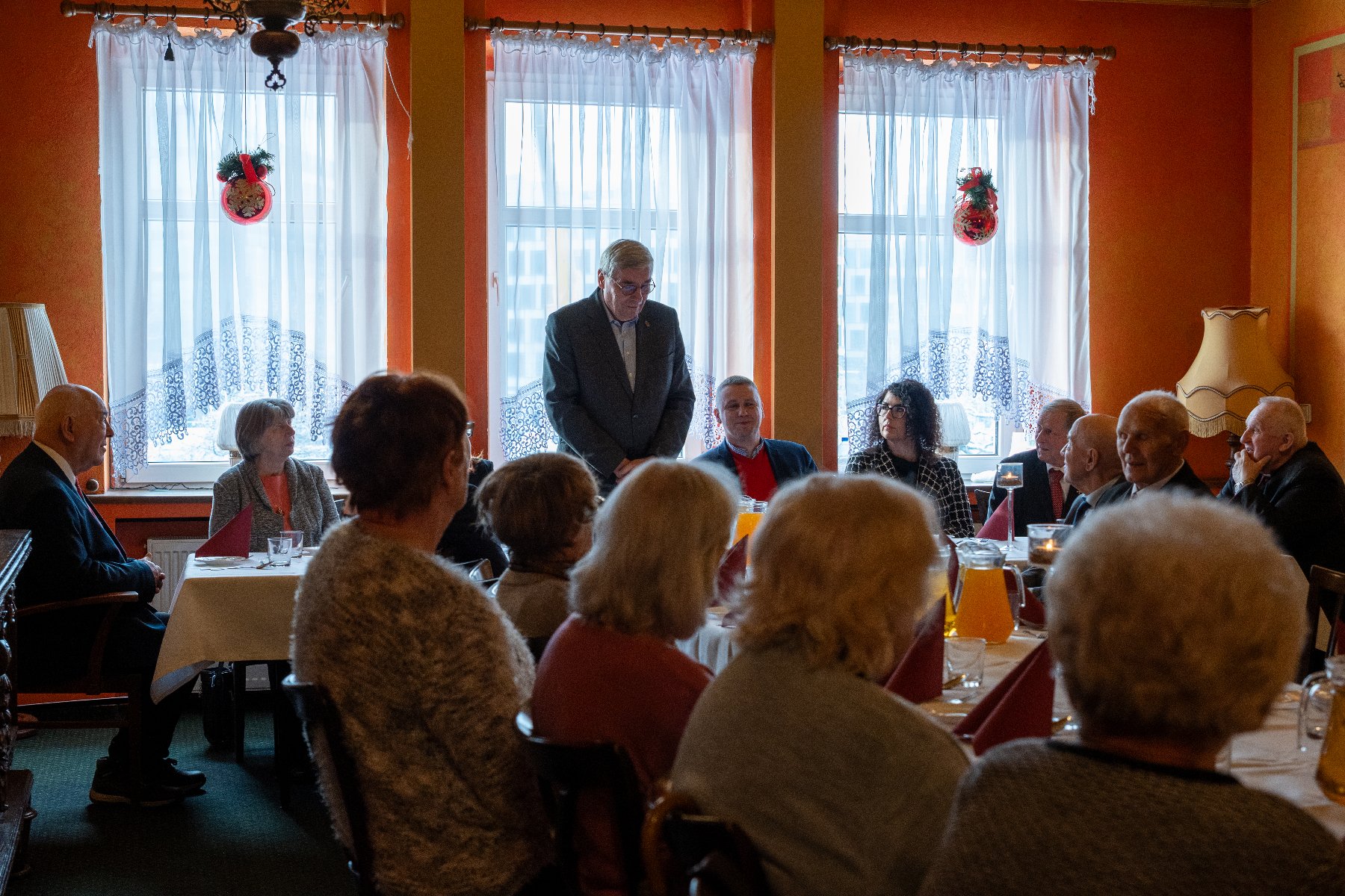 Zdjęcie z uroczystości. W centralnym kadrze stół, przy którym siedzą powstańcy.