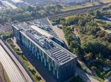 Zdjęcie zostało zrobione z lotu ptaka. W środku kadru znajduje się biurowiec Skalar Office Center widoczny od góry. Za budynkiem widać tory kolejowe. Z lewej strony widać ulicę Hetmańską oraz tory tramwajowe. Z prawej strony budynku widać zadrzewiony teren oraz plac parkingowy.