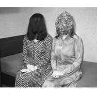 Na fotografi Xue Jianga widzimy dwie siedzące na tapczanie kobiety, które włosami zasłoniły swoje twarze. Zdjęcie czarno białe.