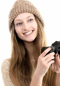 Foto: dziewczyna w czapce z aparatem fotograficznym.