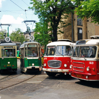 Zdjęcie przedstawia dwa zabytkowe tramwaje i dwa autobusy typu ogórek.