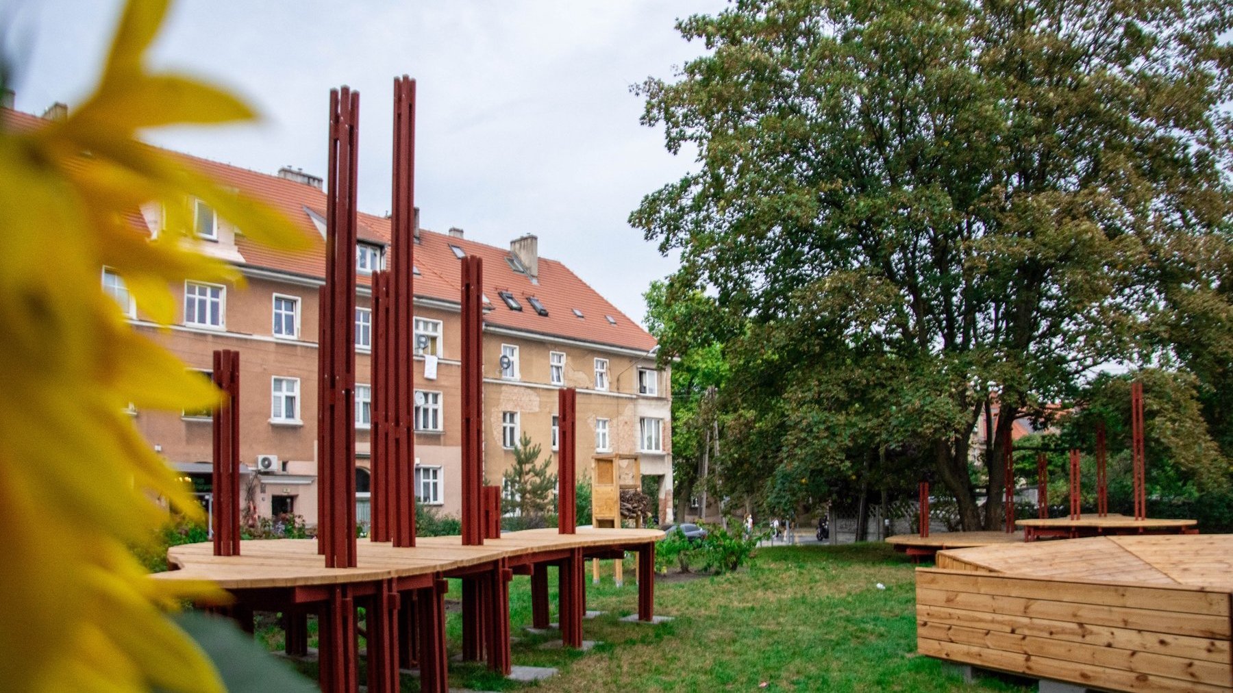 Na zdjęciu ogród, w nim widać duże meble z drewna